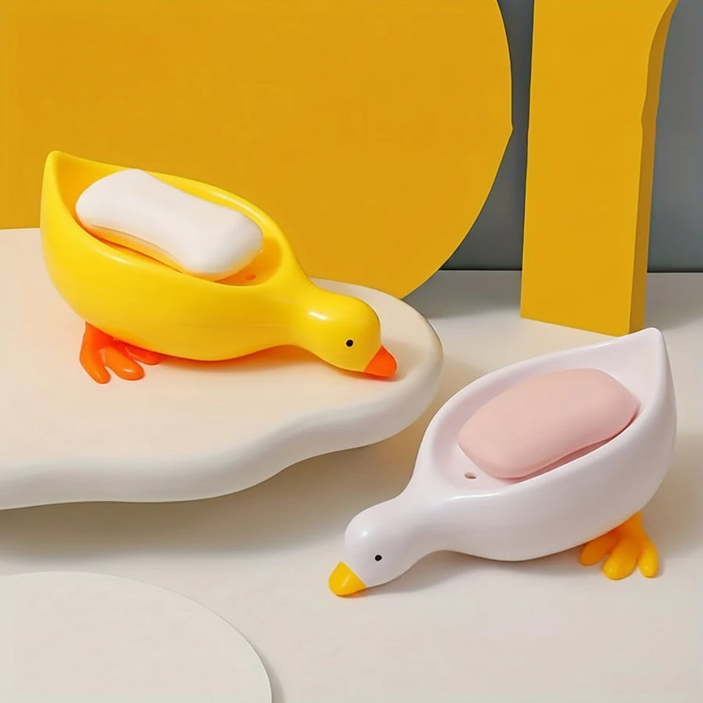 A duck-shaped soap tray with orange feet and a yellow body by TradePro Solutions.