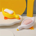 A duck-shaped soap tray with orange feet and a yellow body by TradePro Solutions.