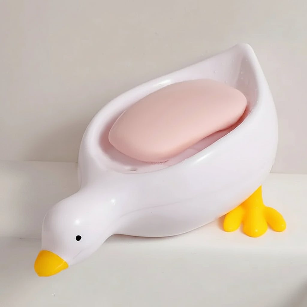 A duck-shaped soap tray with orange feet and a yellow body by TradePro Solutions.