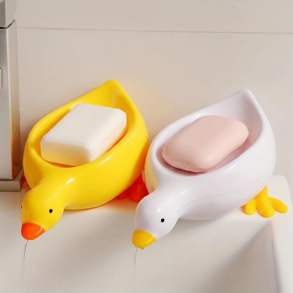 A duck-shaped soap tray with orange feet and a yellow body by TradePro Solutions.