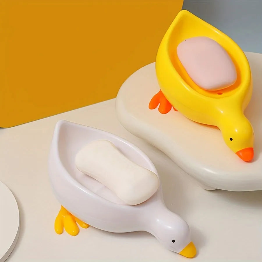 A duck-shaped soap tray with orange feet and a yellow body by TradePro Solutions.